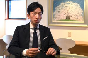 Executive Director Yutaro Oba highlights the sample workpiece as a showcase of SAYAMA MOLD’s technologies 