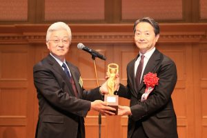 SMC President Yoshiki Takada (right) receives the bronze statue from DMG MORI Vice President and Executive Officer Katsuhisa Shimokawa (left) 